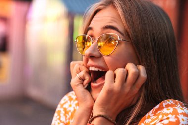 Lunaparkta yürüyen bir kadın yan tarafa bakıyor..