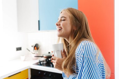 Mutfakta elinde bardakla çay içen tatlı bir kız..