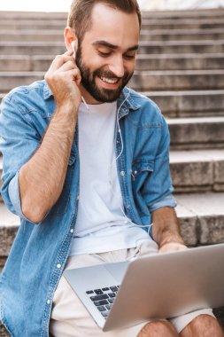 Laptop kullanan yakışıklı genç adam.
