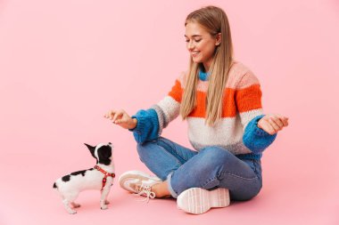 Mutlu güzel kız, evcil köpeğiyle oynuyor.