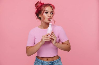 Plastik şişeden içen çekici genç bir kadının portresi.