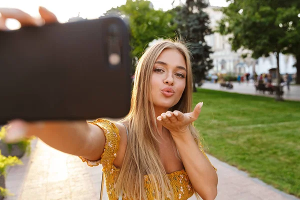 Linda sorridente jovem loira menina tomando uma selfie — Fotografia de Stock