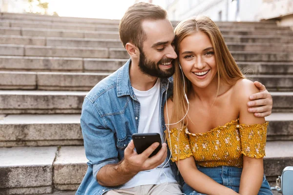 Sorrindo lindo jovem casal sentado juntos em escadas — Fotografia de Stock