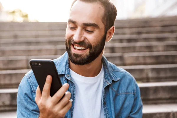 Leende ung man med mobiltelefon — Stockfoto