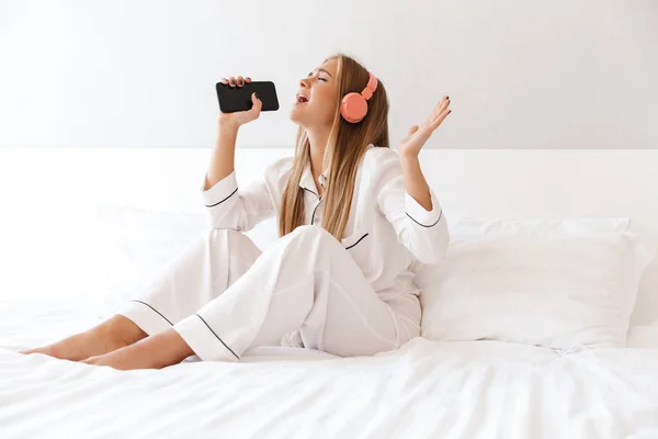 Foto einer jungen glücklichen Frau, die beim Singen Musik hört — Stockfoto