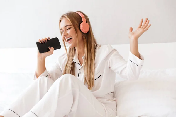 Foto av ung lycklig kvinna lyssnar musik medan du sjunger — Stockfoto