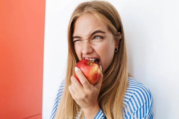 Obraz młodej nastolatki jedzącej jabłko w mieszkaniu — Zdjęcie stockowe