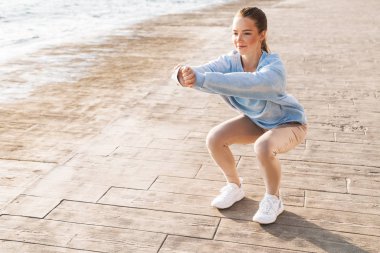 Sahilde spor yapan kadın yoga sporu yapıyor..