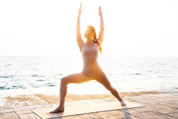 Fitness donna all'aperto sulla spiaggia fare esercizio di yoga sport . — Foto Stock