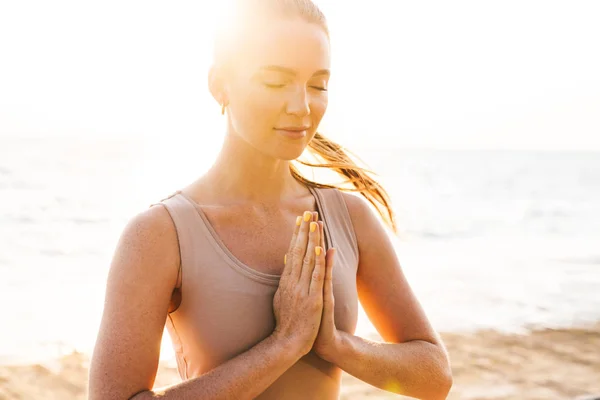 Fitness vrouw mediteren buiten op het strand. — Stockfoto