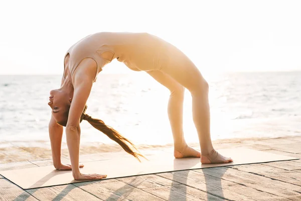 Fitness donna all'aperto sulla spiaggia fare esercizio di yoga sport . — Foto Stock