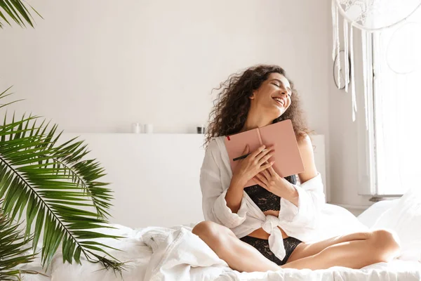 APA 침대에서 란제리 일기를 들고 있는 여성의 사진 — 스톡 사진