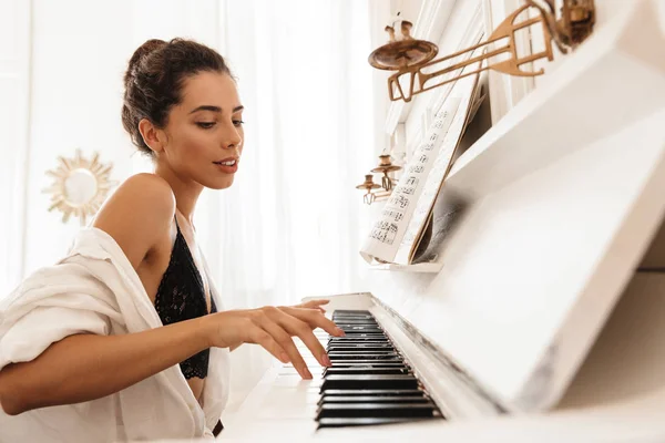 Senhora em lingerie e camisa branca tocar piano — Fotografia de Stock