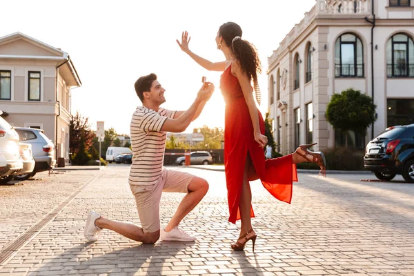 Obrázek šťastného pohledného muže, jak žádá o ruku svou přítelkyni — Stock fotografie