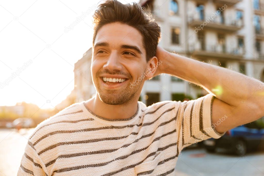 Image of cheerful masculine man smiling and looking aside