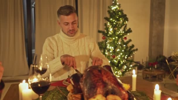 家族や友人は伝統的な食べ物や装飾でクリスマスの前夜を祝う家で休日の夕食を持っています ロースト七面鳥を提示 — ストック動画