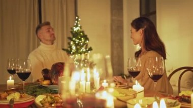 Aile ve arkadaşlar Noel arifesini evde geleneksel yemek ve dekorasyonla kutlayarak, kızarmış hindi sunarak kutlarlar.