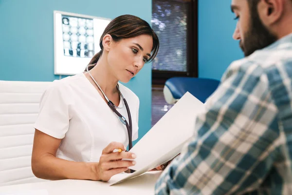 Arzt spricht mit Patient im Krankenhaus am Tisch. — Stockfoto