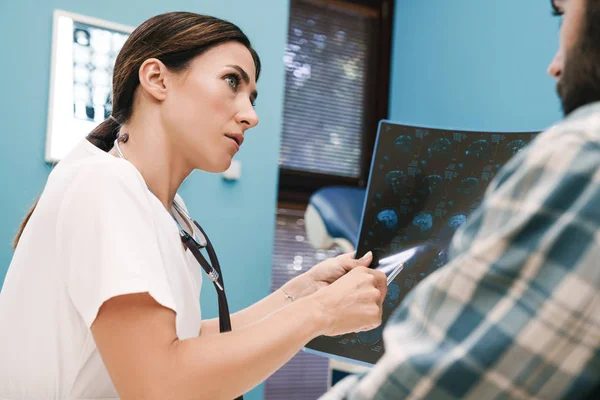 Imagen de la doctora y el paciente mirando la radiografía en — Foto de Stock