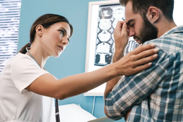 Kuva naislääkärin ja potilaan mies tarkastellaan röntgenkuva sisään — kuvapankkivalokuva