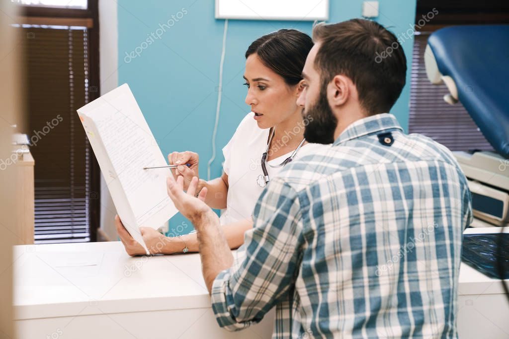 Doctor talking with patient in hospital at the table.