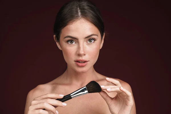 Image of half-naked woman looking at camera and using makeup brush — Stock Photo, Image