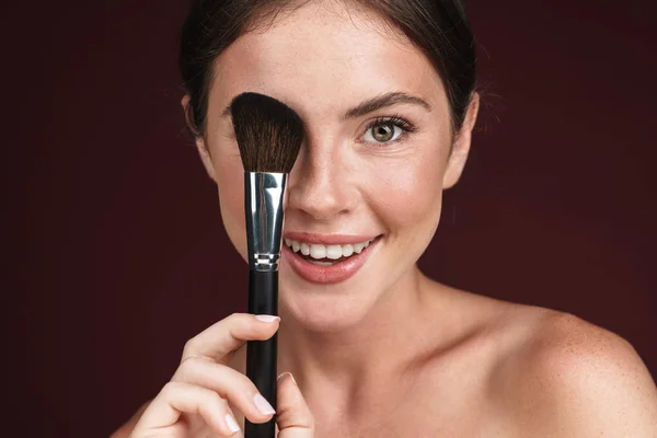 Imagen de mujer alegre semidesnuda usando cepillo de maquillaje — Foto de Stock