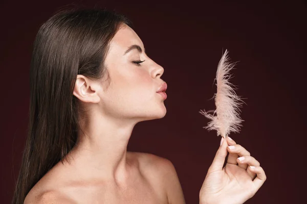 Imagen de una agradable mujer semidesnuda sosteniendo plumas y haciendo labios de beso —  Fotos de Stock