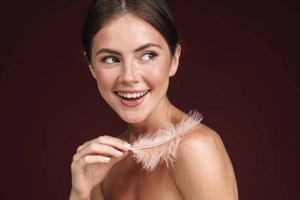 Image of delighted half-naked woman holding feather and looking aside — Stock Photo, Image