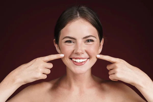 Imagem de mulher semi-nua sorrindo e apontando os dedos para suas bochechas — Fotografia de Stock