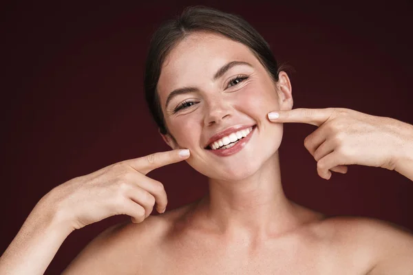 Imagen de mujer semidesnuda sonriendo y señalando sus mejillas con los dedos — Foto de Stock
