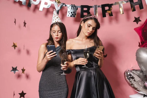 Wizerunek znudzonych imprezowiczek trzymających smartfony podczas świętowania — Zdjęcie stockowe