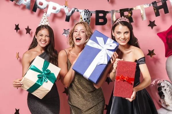 Образ радісної вечірки дівчат у вишуканих сукнях, що тримають гігантський день народження — стокове фото