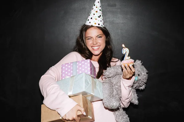 Image of joyful woman holding gift boxes and donut while smiling — Stock Photo, Image