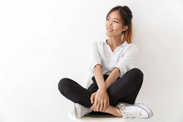 Glimlachende jonge aziatische vrouw dragen casual outfit zitten — Stockfoto