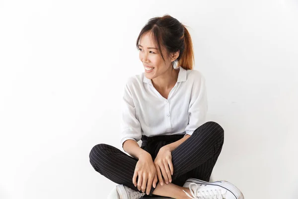 Glimlachende jonge aziatische vrouw dragen casual outfit zitten — Stockfoto