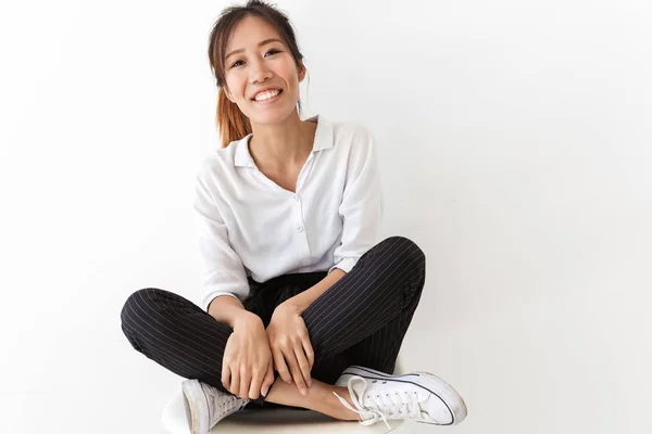 Glimlachende jonge aziatische vrouw dragen casual outfit zitten — Stockfoto
