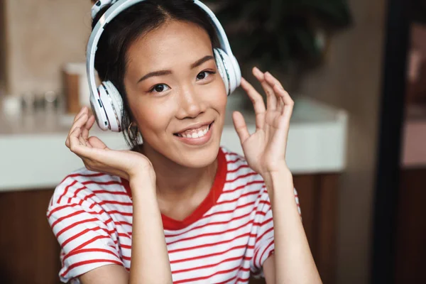 Portrait of joyful asian woman listening to music with headphone — Stock Photo, Image