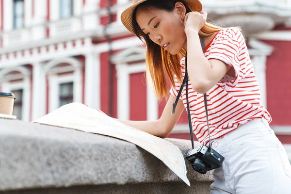 Mooie aziatische vrouw wandelen buiten houden kaart. — Stockfoto