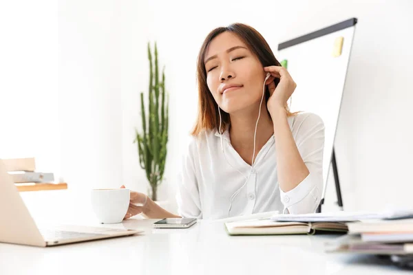 Imagem de mulher de negócios asiática ouvindo música com fones de ouvido i — Fotografia de Stock