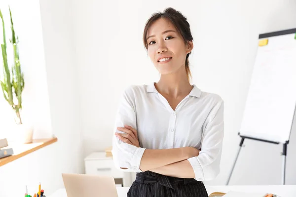 Впевнена приваблива молода азіатська бізнес-леді, що стоїть в її офісі — стокове фото