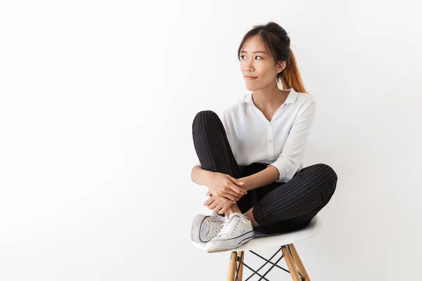 Attractive young asian woman sitting on a chair — Stock Photo, Image