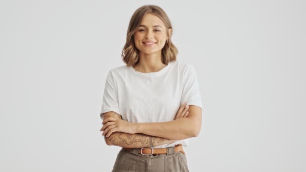 Sorrindo Jovem Mulher Vestindo Camiseta Básica Com Braços Dobrados Isolado — Vídeo de Stock