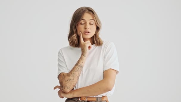 티셔츠를 여성은 손가락으로는 배경에 고립되어 그녀의 모방의 공간을 바라본다 — 비디오