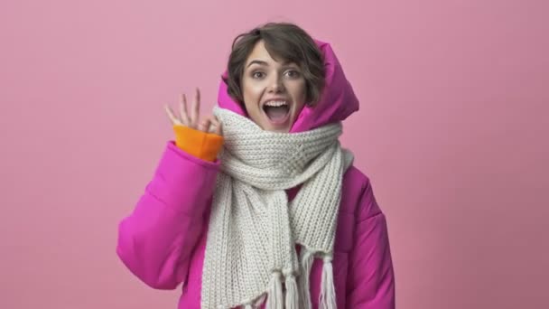 Eşarplı Kışlık Ceket Giyen Mutlu Genç Bir Kadın Pembe Arka — Stok video