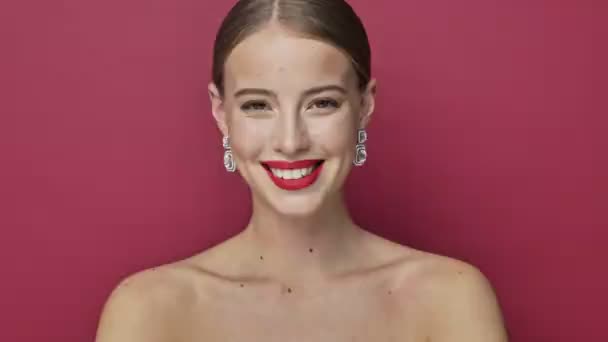Flirty Young Woman Red Lipstick Earrings Winking Isolated Red Background — Stock Video