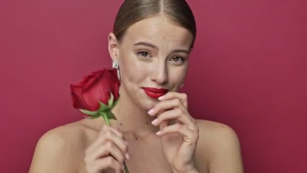 Красивая Молодая Женщина Красной Помадой Серьги Принимает Красный Цветок Розы — стоковое видео