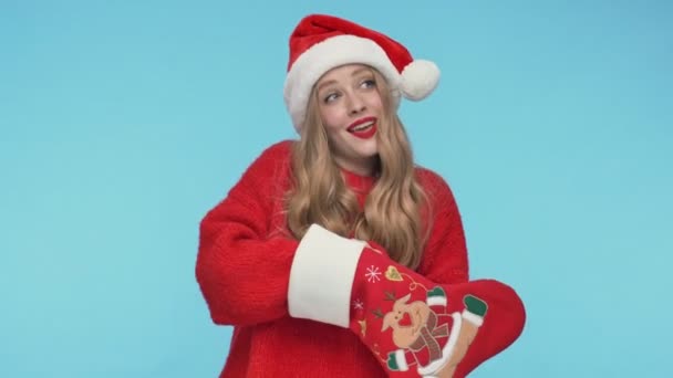 Χαρούμενη Όμορφη Γυναίκα Χριστουγεννιάτικο Καπέλο Ψάχνει Για Κάτι Χριστουγεννιάτικη Κάλτσα — Αρχείο Βίντεο