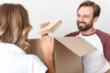 Karton kutuların yanında duran mutlu çiftin el kitabının fotoğrafı