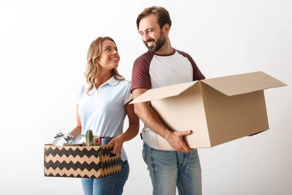 Foto de casal satisfeito segurando caixas de papelão enquanto olham um para o outro — Fotografia de Stock